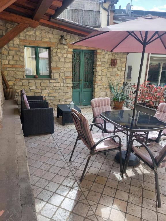 a patio with a table and chairs and an umbrella at La Casa nel Borgo in Bergamo