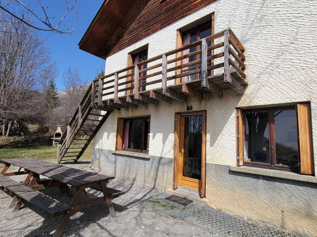 ein Gebäude mit einer Holzterrasse und einem Picknicktisch in der Unterkunft Chalet Saint-Michel-de-Chaillol, 10 pièces, 18 personnes - FR-1-393-82 in Saint-Michel-de-Chaillol