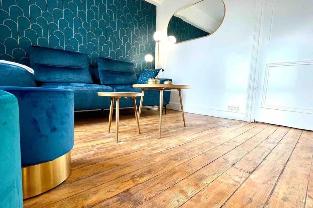 un salon avec un canapé bleu et deux tables dans l'établissement Jolie maison centre historique, à Honfleur