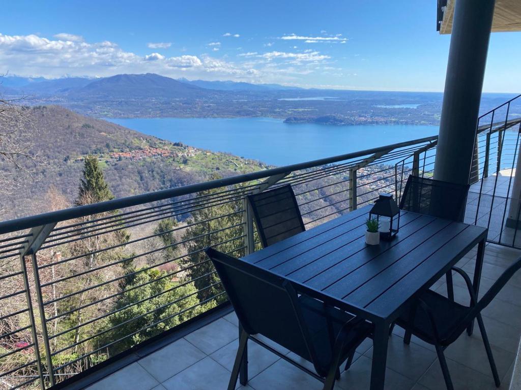 a table on a balcony with a view of a lake at Dolcevista Apartment in Massino Visconti