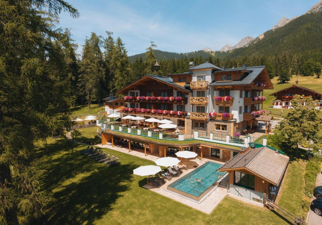 einen Luftblick auf ein Resort mit einem Pool in der Unterkunft Hotel Lindenhof in Ramsau am Dachstein