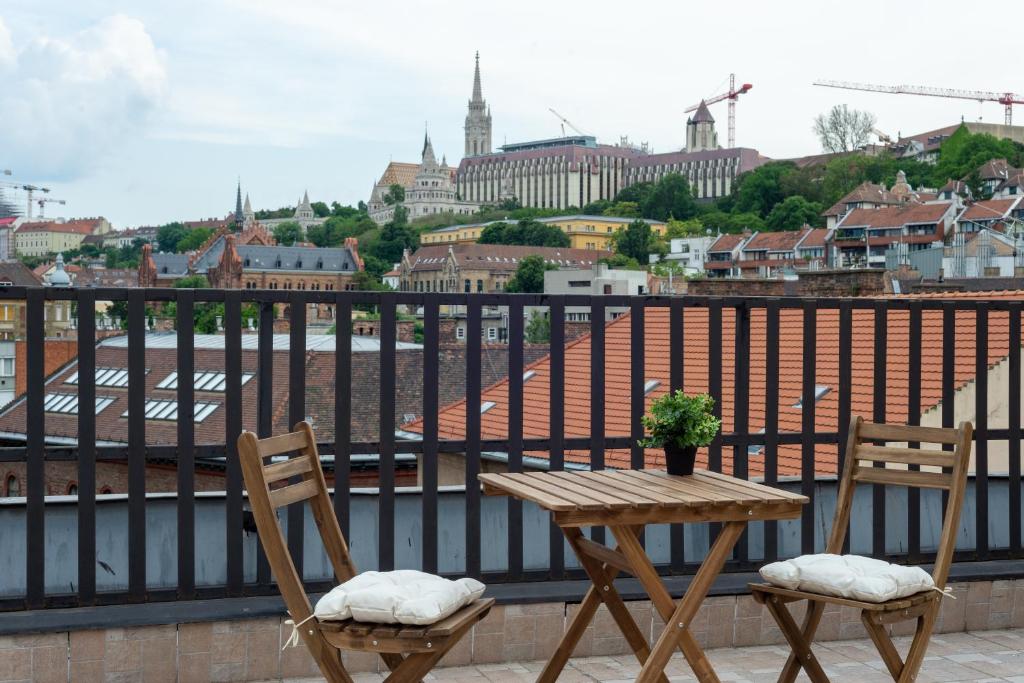 a table and chairs on a balcony with a view of a city at ROOF TERRACE access CASTLE dst. PARLIAMENT 1stop in Budapest