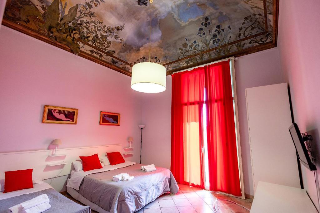 1 dormitorio con 2 camas y una pintura en el techo en Promenade B&B, en Catania
