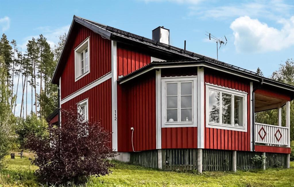 a red house with white windows on a field at Amazing Home In Hunge With 4 Bedrooms in Bräcke