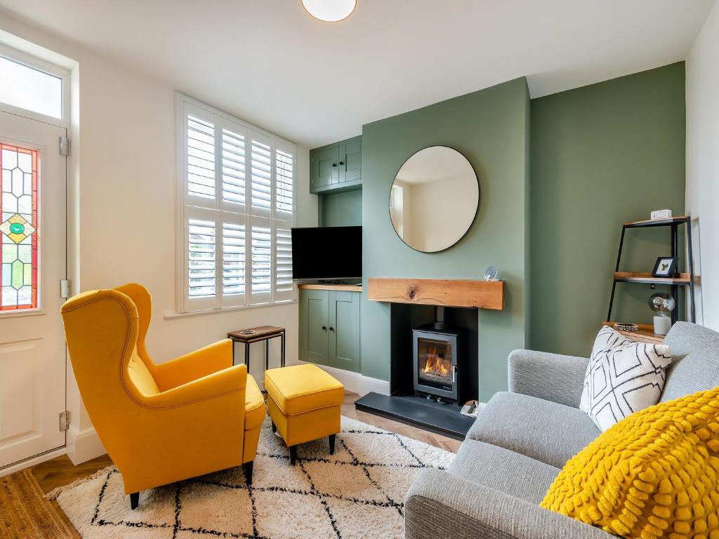 a living room with a couch and a fireplace at Ivy Cottage in Belper