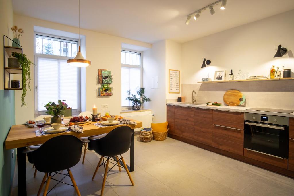 una cucina con tavolo, sedie e bancone di Pari Lindenau a Lipsia