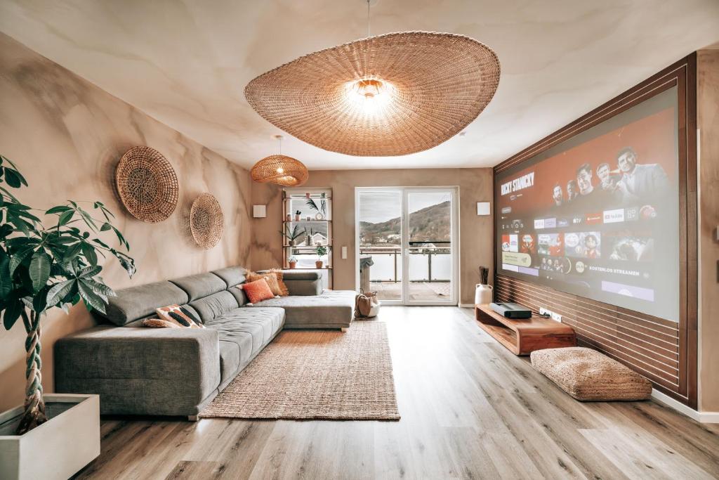 a living room with a couch and a large screen at GetAway Penthouse: Spa & Cinema in Echternacherbrück