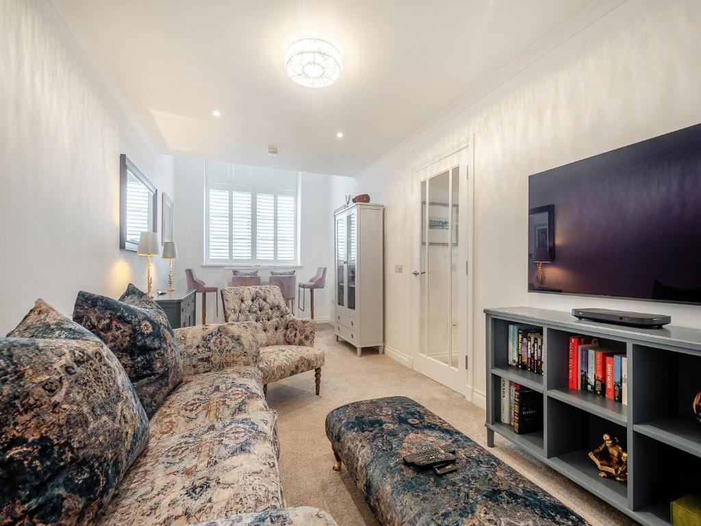 een woonkamer met banken en een flatscreen-tv bij Luxury Moffat Apartment in Moffat