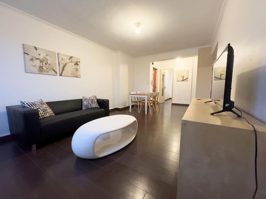 a living room with a couch and a television at Le Cavaignac -2 chambres proche de Saint Charles in Marseille