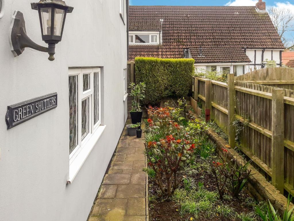 a side walk to a house with a flower garden at Green Shutters in Harmston