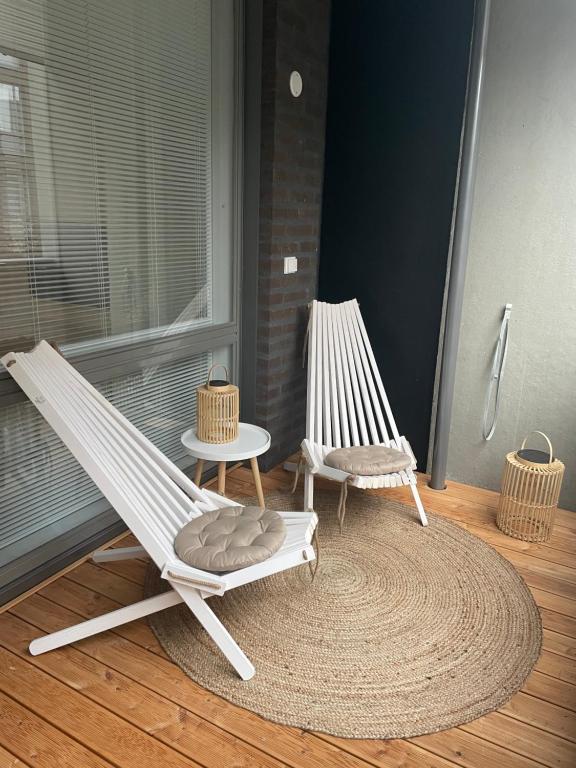 um alpendre com duas cadeiras de baloiço e um tapete em Yksiö loistavalla sijainnilla sekä yhteyksillä em Vantaa
