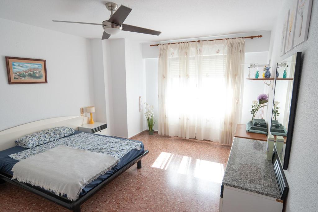Schlafzimmer mit einem Bett und einem Deckenventilator in der Unterkunft An apartment in Xeraco with 3 bedrooms, located near beach and Gandia in Xeraco