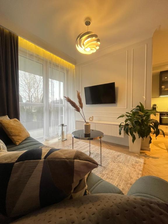 un soggiorno con un divano e una TV di Apartamenty Kielce- Apartament Komfort przy Baseny Tropikalne, Kadzielnia, parking, faktura, centrum a Kielce