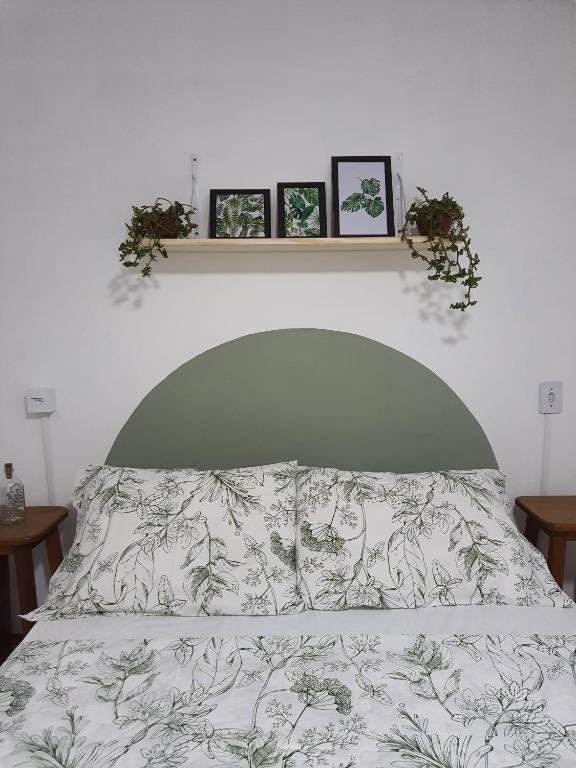 1 dormitorio con 1 cama con 3 cuadros en la pared en Casa Groot, en Holambra