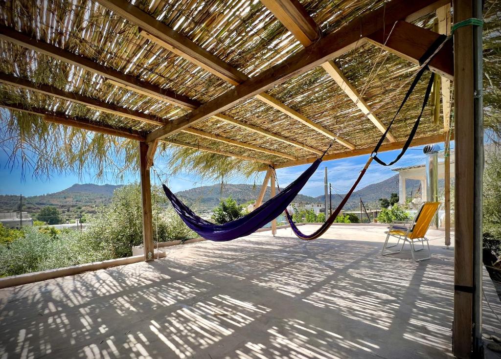 a hammock hanging from a pergola on a house at La Maison Bleue in Zaros