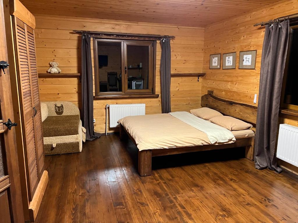 a bedroom with a bed in a wooden room at Kozichky Guest House in Tatariv