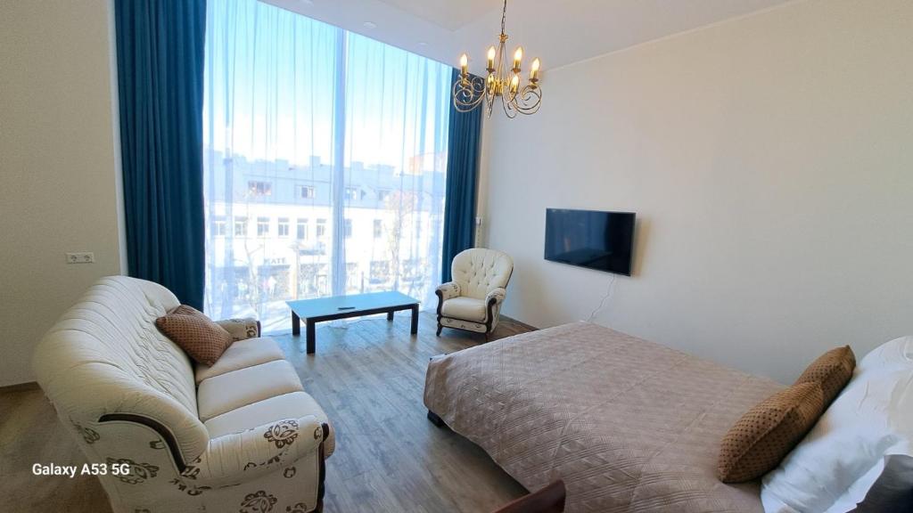 a bedroom with a bed and a couch and a tv at KaunasInn LA in Kaunas