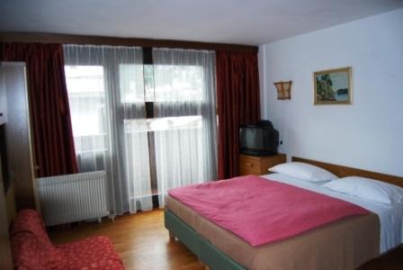 1 dormitorio con 1 cama y TV en una habitación en Campiglio Monolocale Cima Tosa, en Madonna di Campiglio