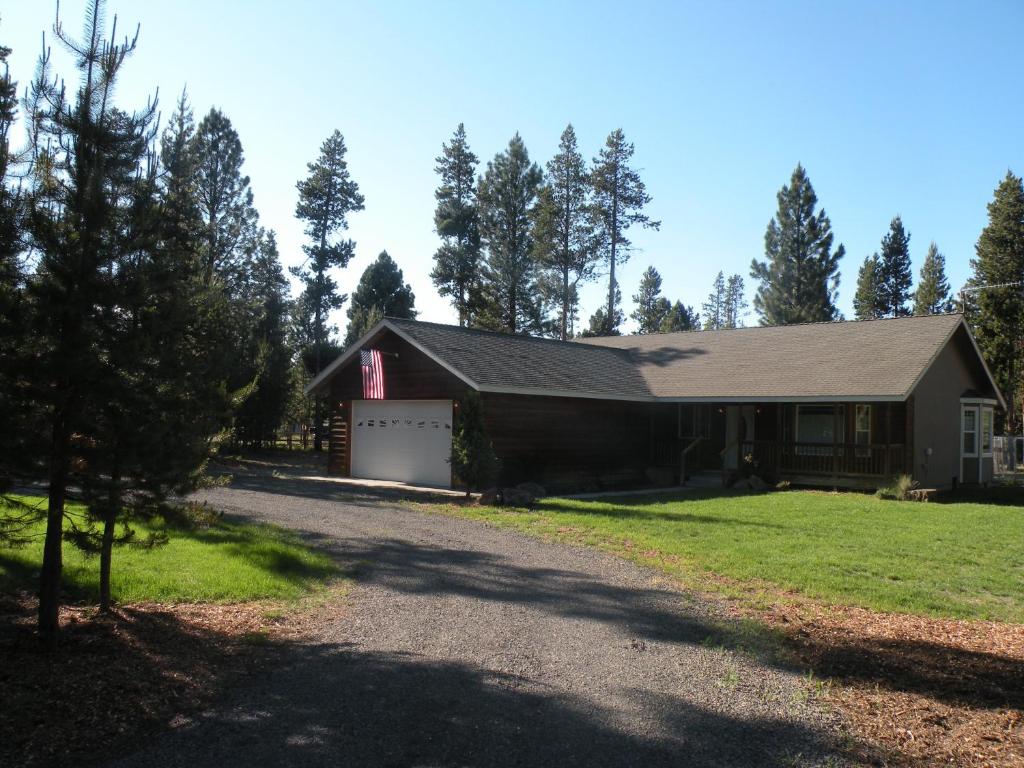 a house with a driveway leading to a garage at Cozy Cabin LaPine in La Pine