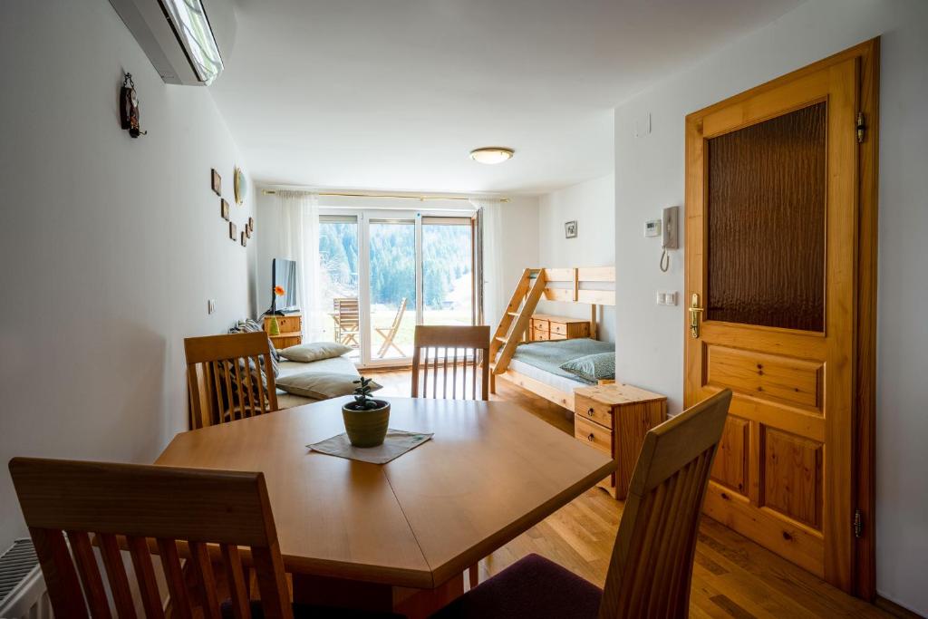 a dining room and living room with a table and chairs at Apartma Pokljuška idila - Idyllic Pokljuka Studio above Bled in Bled
