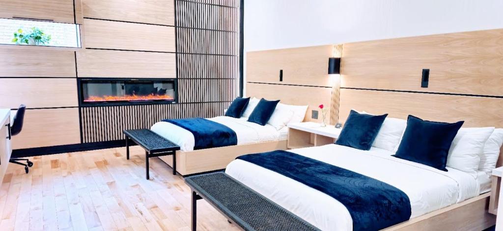 duas camas num quarto de hotel com lareira em Cribs on Main em Picton