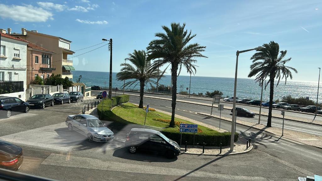 a street with cars parked on a road near the ocean at MAR VERDE - Parede-Cascais in Parede