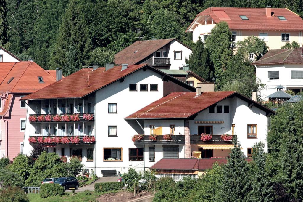 ein großes weißes Gebäude mit roten Dächern in der Unterkunft Aparthotel Schwarzwald Panorama in Bad Wildbad