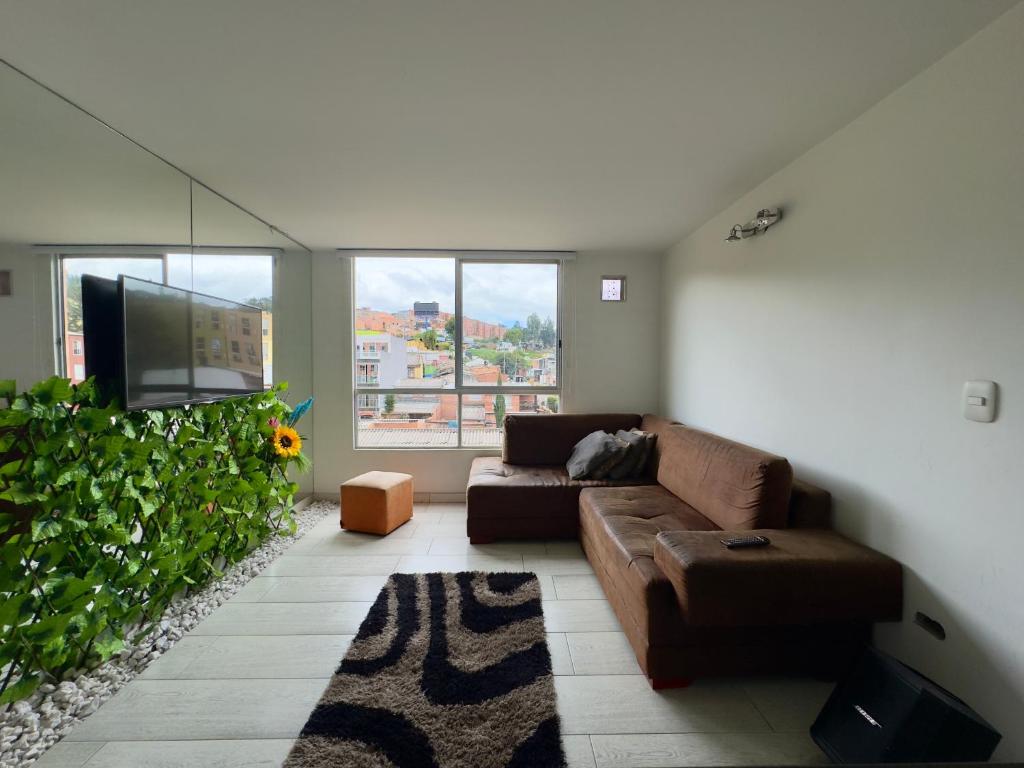 a living room with a couch and a tv at Apartamento en Bogotá in Bogotá