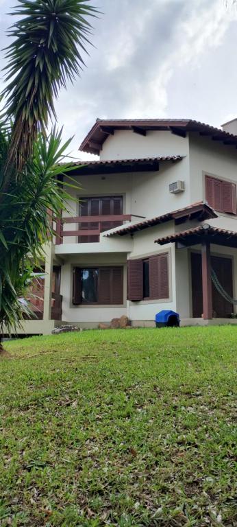 ein Haus mit einer Palme vor einem Hof in der Unterkunft Hostel de gaia in Santa Cruz do Sul