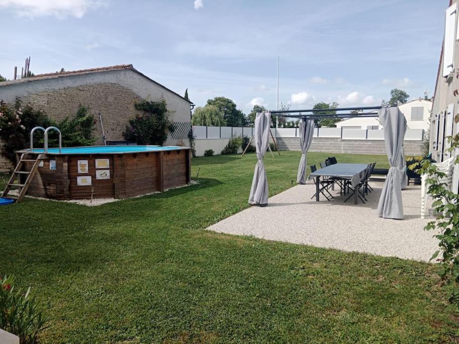 a backyard with a picnic table and a trampoline at Maison à la campagne avec piscine 12 pers in Genouillé