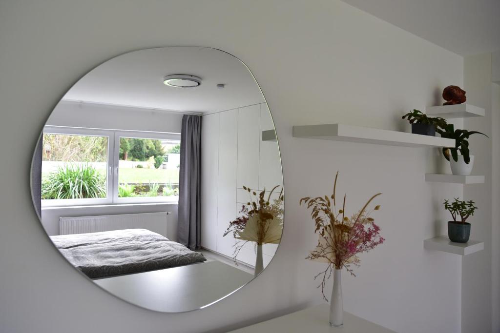 einen Spiegel in einem weißen Zimmer mit einem Bett in der Unterkunft Top Wohnung in Refrath bei Köln in Bergisch Gladbach