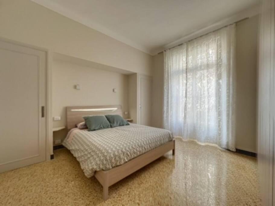 une chambre avec un lit et une grande fenêtre dans l'établissement Appartement central rue Hoche, à Cannes