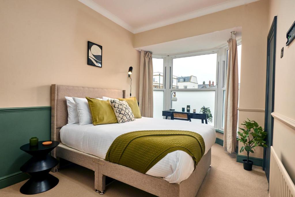 una camera da letto con un letto e una grande finestra di Settle in Winchester - Stylish Self Check-In Rooms a Winchester
