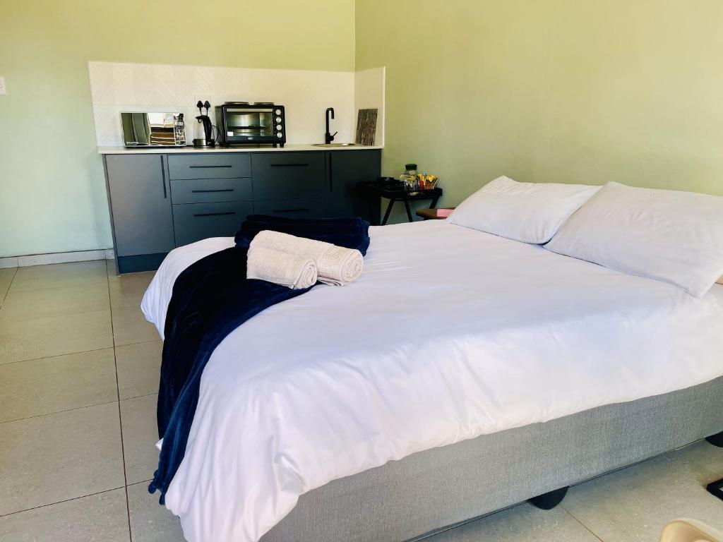 1 cama blanca grande con 2 toallas encima en Room in BB - TrendyBliss Guest House - Room 4, en Northam