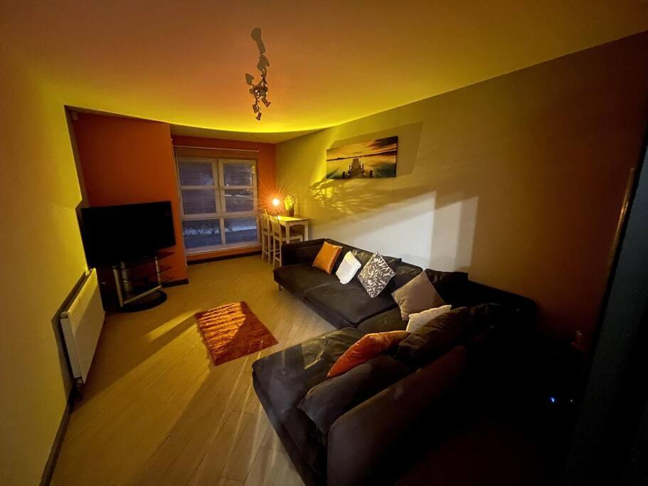 sala de estar con sofá y TV en Aberdeen Beach 2 Bed Apartment en Aberdeen