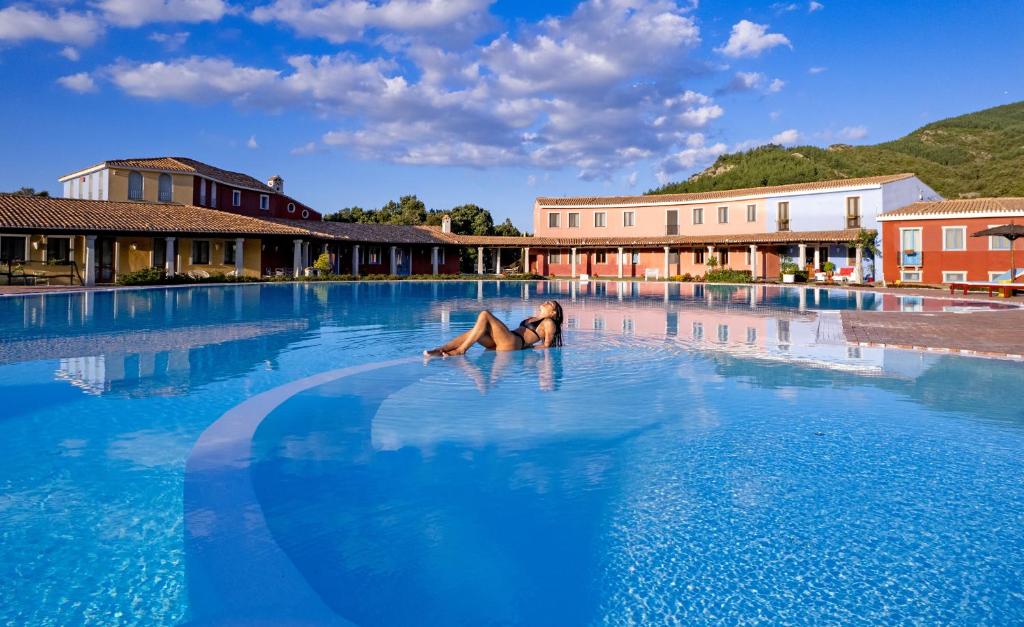 a woman laying in the middle of a swimming pool at ECO HOTEL ORLANDO Sardegna in Villagrande Strisaili