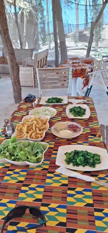 una mesa con platos de comida en la parte superior en Poco Loco B&B, en Abémé