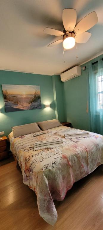 1 dormitorio con 1 cama y ventilador de techo en Semi-detached Adosado con Encanto -130 m2 - WiFi 600 Mb - Piscina Comunitaria - Patio Privado, en Torremolinos