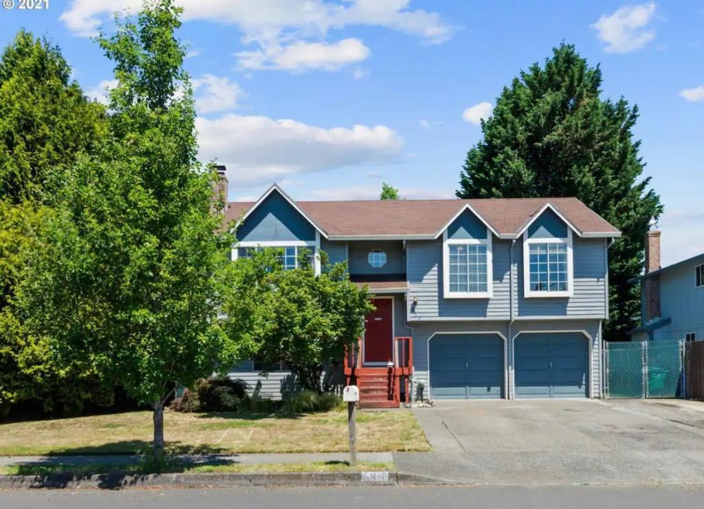 a blue house with a red door at Private level of the house with SPA in Gresham