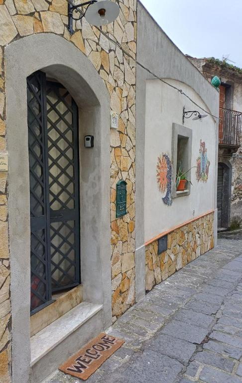 a door to a building with a stone wall at Etnalcantara16 in Castiglione di Sicilia