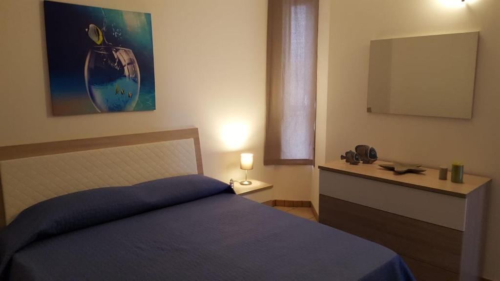 a bedroom with a blue bed and a television at VELA BIANCA in Punta Braccetto