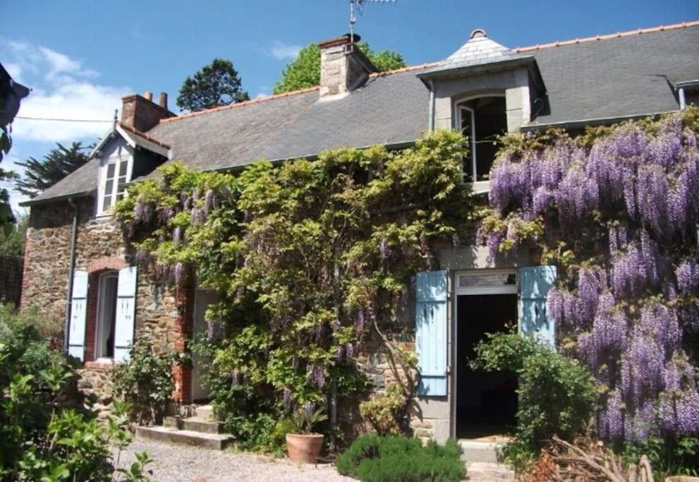 une maison avec des glycines sur son côté dans l'établissement Maison de charme avec jardin à Dahouët, à Pléneuf-Val-André