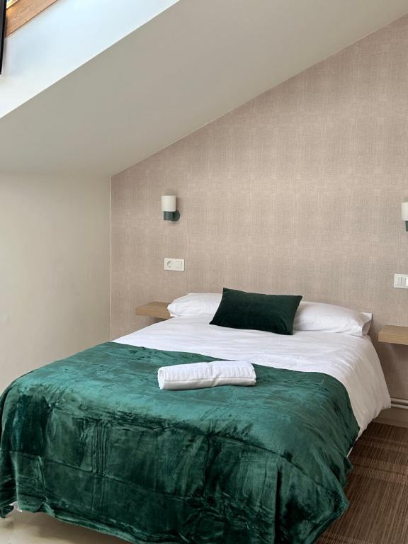1 dormitorio con 1 cama grande con manta verde en Casa Grande do Costureiro Portomarín Camino de Santiago Francés, en Portomarín