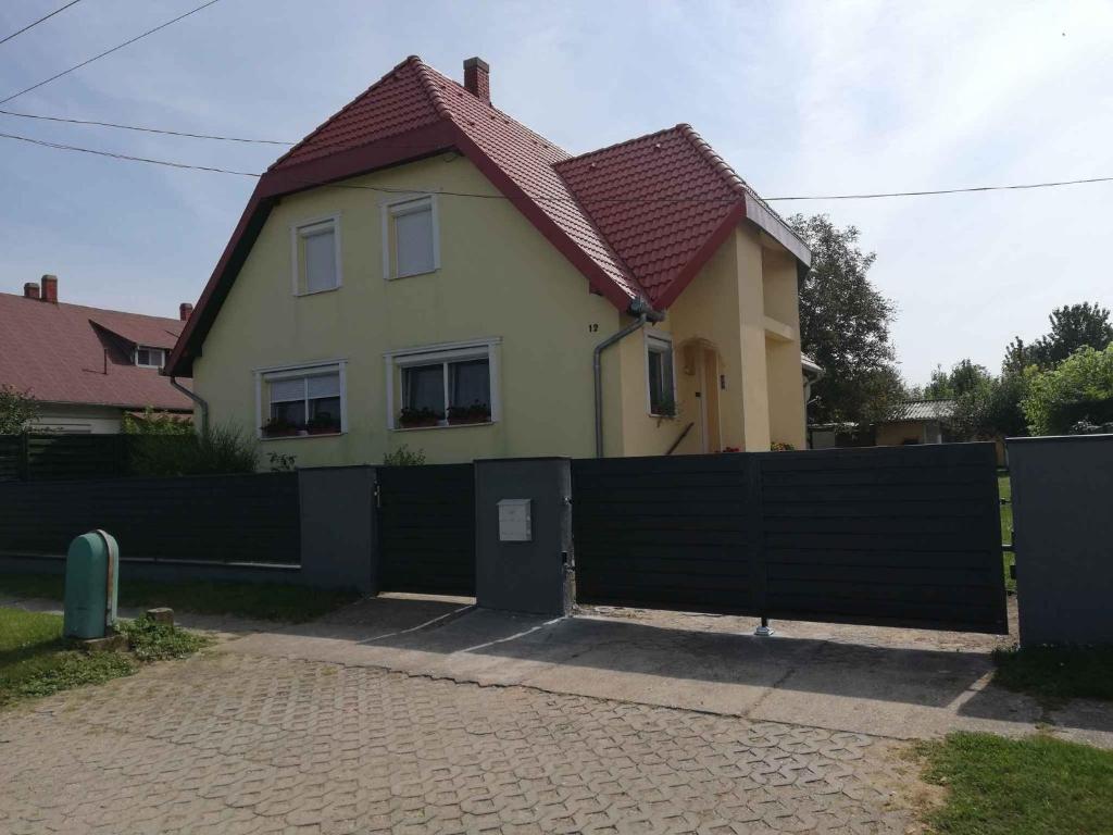 a house with a fence in front of it at Holiday home Balatonbereny - Balaton 18030 in Balatonberény