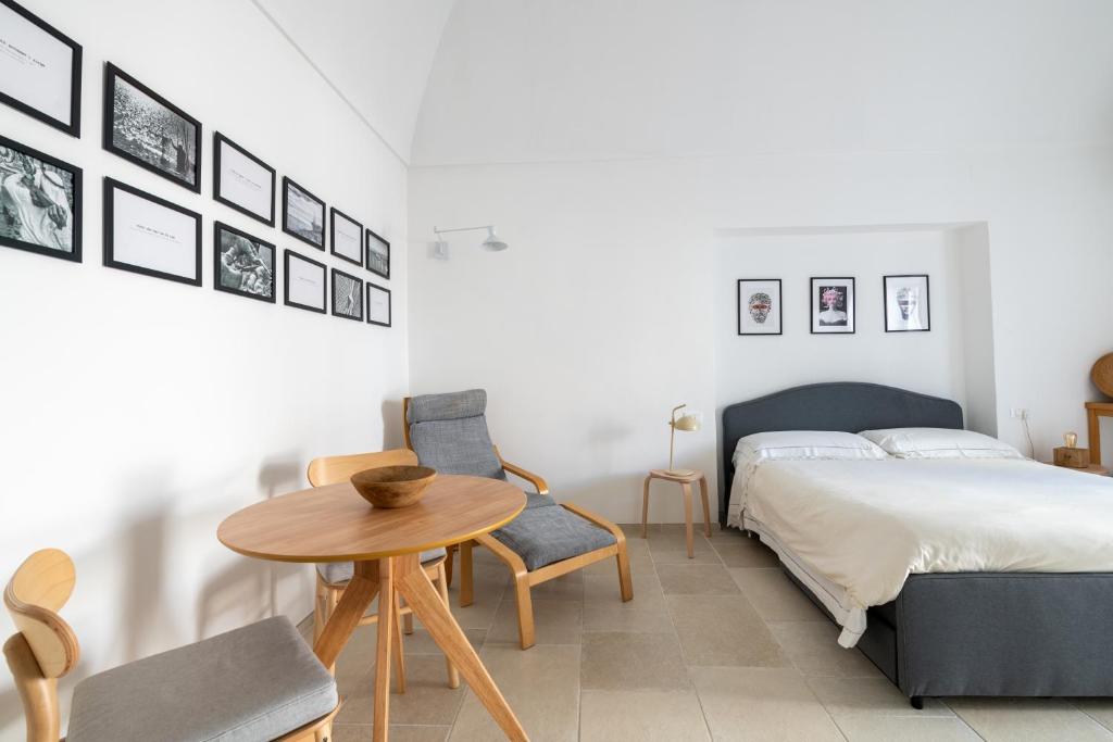 una camera con letto, tavolo e sedie di Minimà Peschici a Peschici