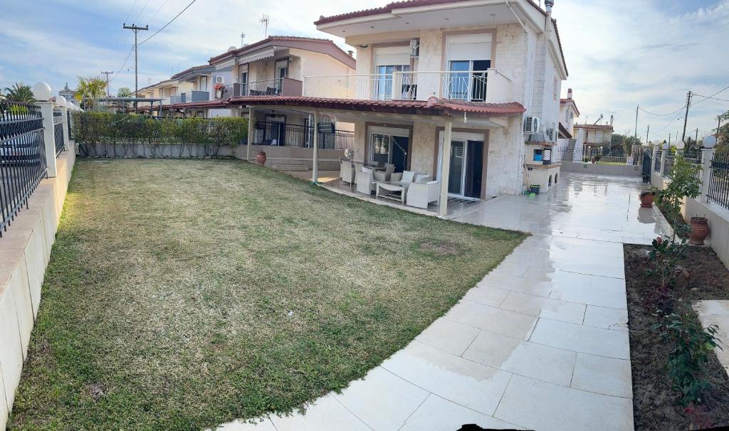 une maison avec une pelouse devant elle dans l'établissement Villa nea Flogita 90m from the sea, à Flogita