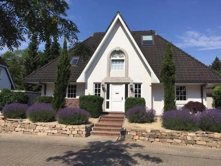 a white house with purple flowers in front of it at Weedkroog in Timmendorfer Strand