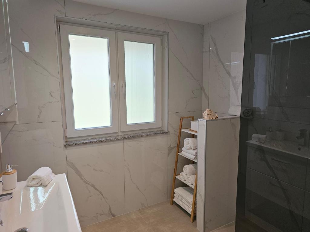 a bathroom with a window and a shower and a sink at Appartment Jasmin in Liezen