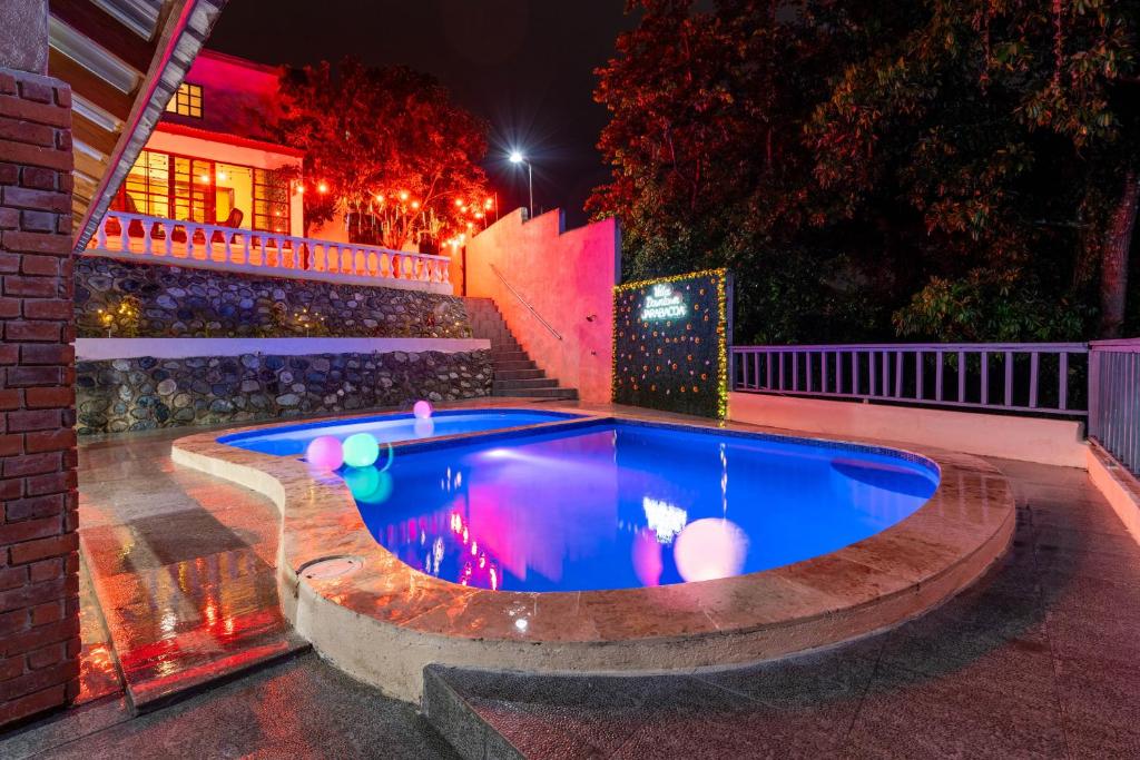 a swimming pool in a backyard at night at Villa downtown jarabacoa in Jarabacoa