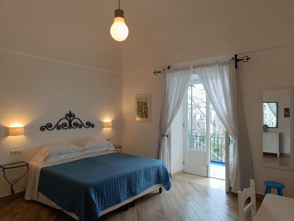 a bedroom with a bed with a blue blanket at Regina Margherita in Positano